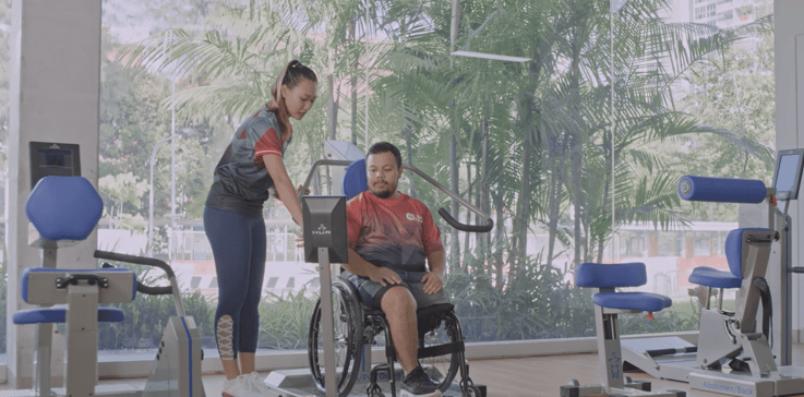 A volunteer and a participant on wheelchair at inclusive ActiveSG gym