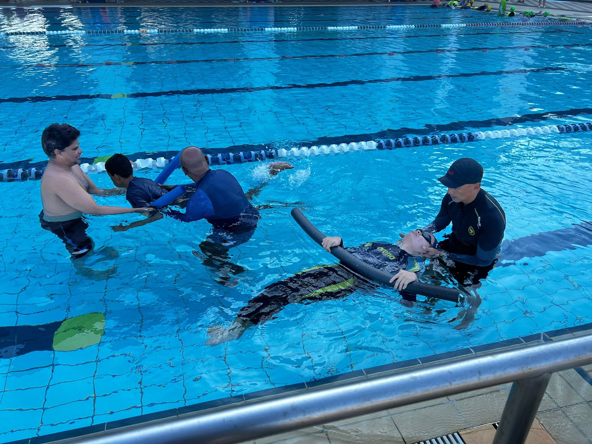 Para Sport Academy photo of coaches guiding two learners in swimming