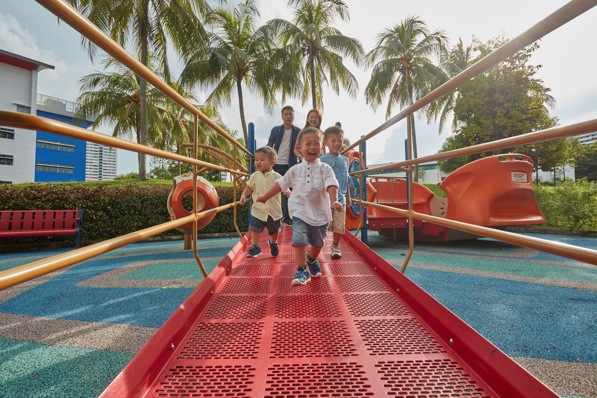 A family of 5 smiling while playing at the playground